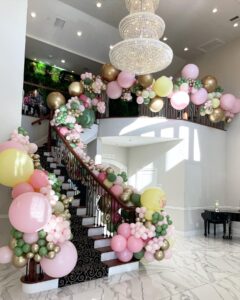 green, yellow, and pink sweet 16 balloons on stairs
