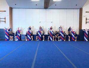 cheerleaders with school color balloon arches