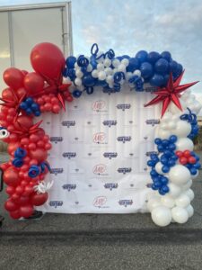 red white and blue balloon arch and photo backdrop